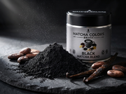 Macro de polvo negro con habas de cacao y vainas de vainilla junto a la lata de Black Matcha Blend - campaña IA