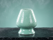 Macro del soporte de ceramica verde menta de Matcha Colors con gotas de agua sobre el esmalte brillante - campaña IA